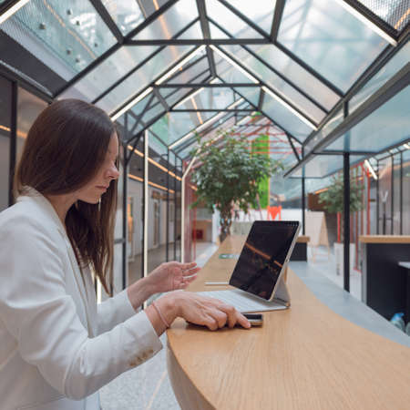 Exchange analytics and investments. Trading on the stock exchange and buying financial funds from anywhere in the world, remote account management. business woman in a white jacket with modern laptopの写真素材