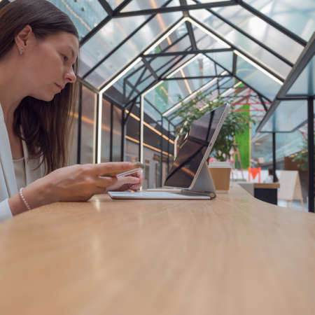 Exchange analytics and investments. Trading on the stock exchange and buying financial funds from anywhere in the world, remote account management. business woman in a white jacket with modern laptopの写真素材