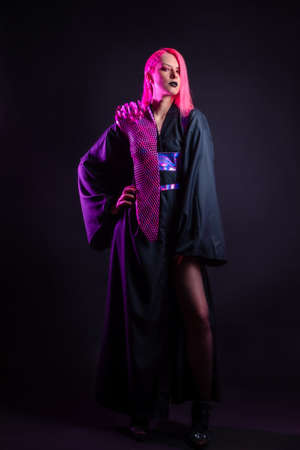 Fashion of the future, multicultural outfit with elements printed on a 3D printer. Stylish young woman with pink hair and black lips in a gothic cyber image, 3D printing and a classic kimonoの写真素材