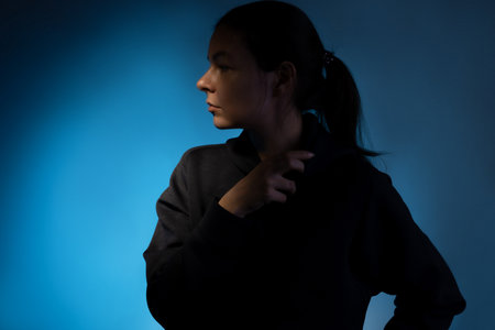 Hard light, face in partial shade. Work of thought, concept. The birth of an idea, a cognitive process in the mind. Young woman portrait side viewの写真素材