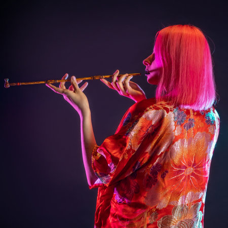 Futuristic look, multicultural outfit, young woman with pink hair in modern trousers, vintage kimono and smoking a pipe in her handsの写真素材