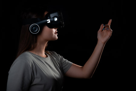 Virtual experience, a young woman using virtual reality glasses, playing a game or interacting with a metaverse, A girl in vr glasses touches a virtual objectの写真素材