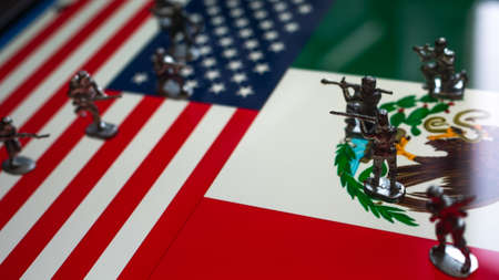 The concept of the economic and political crisis between the United States and Mexico, toy soldiers attacking each other against the background of national flags.の写真素材