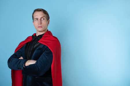 superhero stands in a heroic pose, a man in a business suit and a red cape. charismatic and successful business hero.の写真素材
