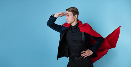 The superhero hurries forward, a man in a business suit and a red cape. charismatic and successful business hero.の写真素材