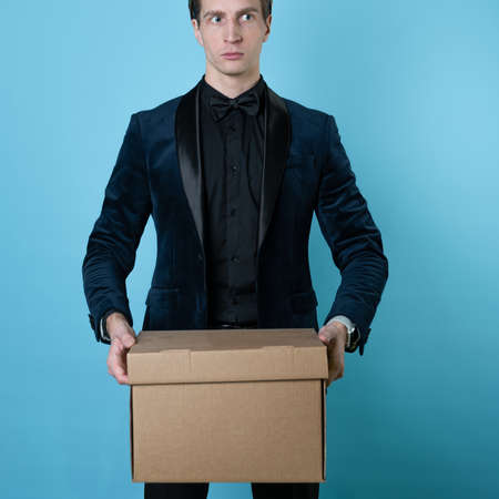 Relocation of a business, bankruptcy of a company or labor migration. A man in a business suit carries a box of things.の写真素材