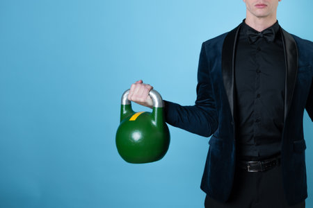 A businessman lifts a kettlebell. The concept of difficult problems and their solutions in business.の写真素材