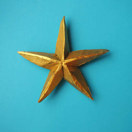 Golden craft star on a blue background, a symbol of celebration and dreamsの写真素材