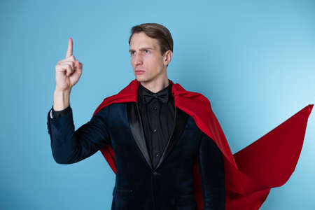 superhero stands in a heroic pose, a man in a business suit and a red cape. charismatic and successful business hero.の写真素材
