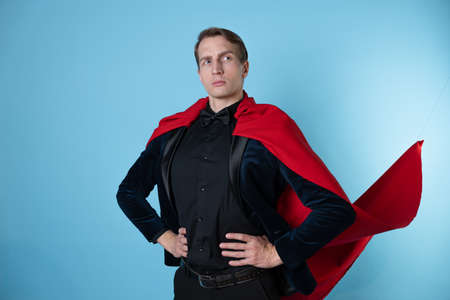 superhero stands in a heroic pose, a man in a business suit and a red cape. charismatic and successful business hero.の写真素材