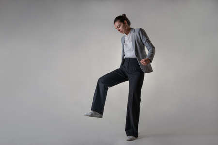 A young businesswoman in the image of a giant is trampling on something, an empty space for your design.の写真素材