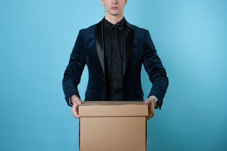 Relocation of a business, bankruptcy of a company or labor migration. A man in a business suit carries a box of things.の写真素材