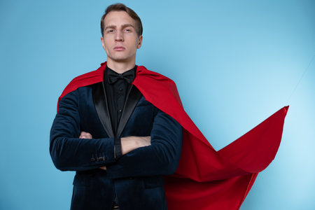 superhero stands in a heroic pose, a man in a business suit and a red cape. charismatic and successful business hero.の写真素材