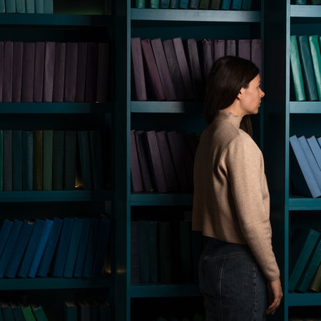 Exam stress, tired girl on the background of bookshelves. Natural sciences. A large amount of information. Student in the library, laconic minimalistic styleの写真素材