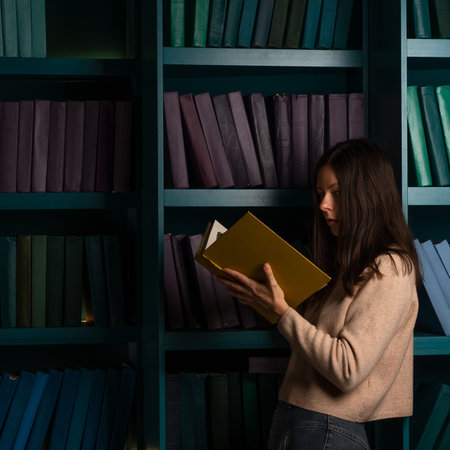 Higher education, training in complex specialties, concept. Natural sciences. A large amount of information. Student in the library against the background of bookshelves, laconic minimalistic styleの写真素材