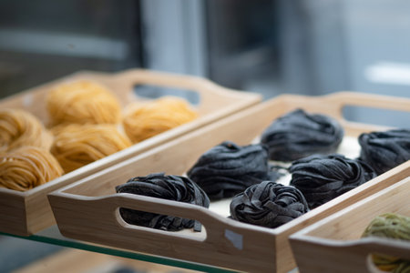 Black Italian spaghetti on showcase, tagliatelle, dry, uncooked spaghetti shopの写真素材