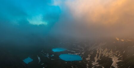 Azgara mountain lakes in last beams of sun. Top view through clouds. Caucasus mountains. Karachay-Cherkessia. Russia.の写真素材