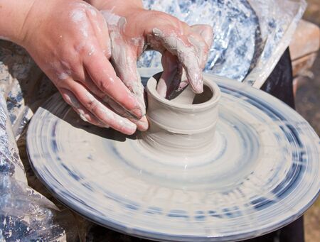 Potter hands working on pottery wheel の写真素材