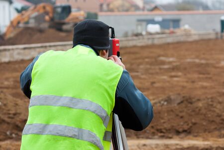 Building surveyor taking measurements on a construction siteのeditorial素材