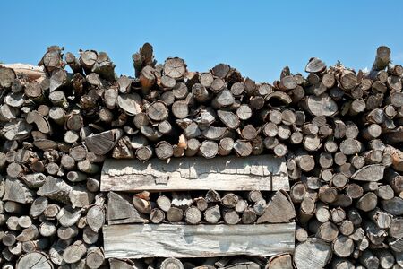 A lot of wooden logs on a blue sky background