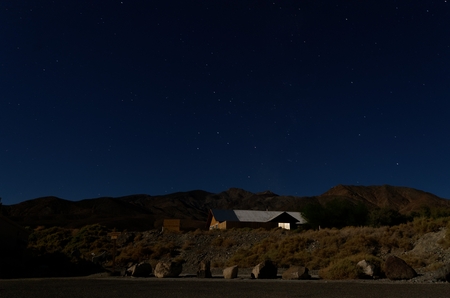 House in the middle of the desert at nighttime with a starry skyの写真素材