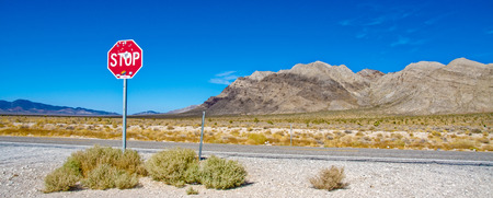 A stop sign next to the highway outside an entrance to Area 51, Nevadaの写真素材