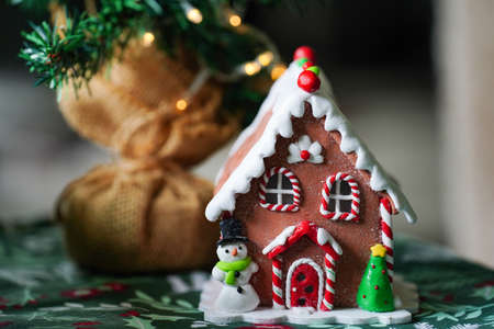 Gingerbread house Christmas decoration with a snowman and Christmas Treeの写真素材
