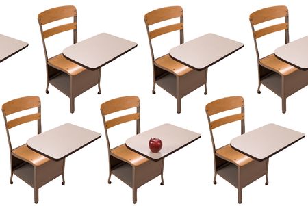 School desks in rows and one desk with an apple isolated over a white backgroundの写真素材