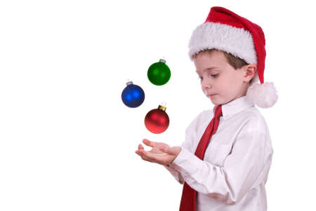 Boy in Christmas hat with ornaments in his hands isolated over whiteの写真素材