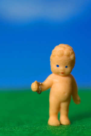 small doll with bracelet outside on grassの写真素材