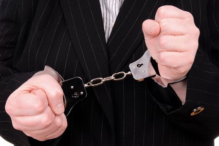 Business person in suit in handcuffsの写真素材