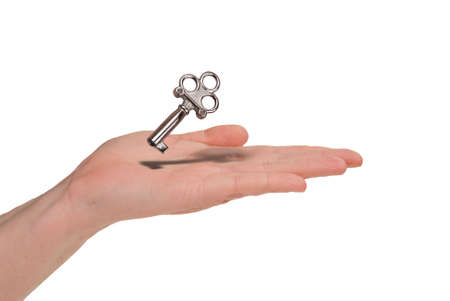 Woman holding a key in her hand isolated over whiteの写真素材