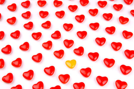 Red and yellow candy hearts isolated over whiteの写真素材