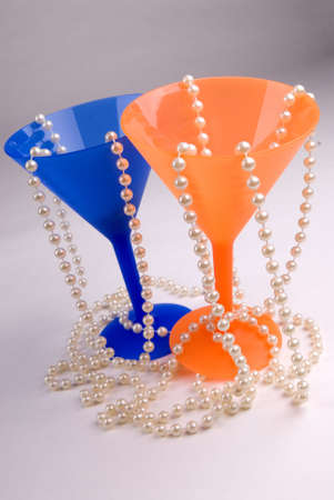 Blue and orange plastic martini glasses with pearlsの写真素材
