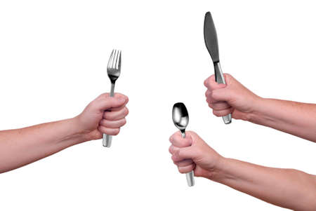 Fork,knife and spoon held by a woman's hands isolated over whiteの写真素材