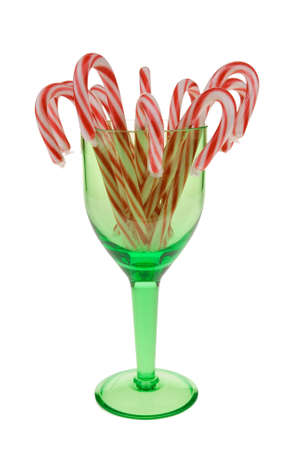 Candy canes inside of a green wine glass over whiteの写真素材