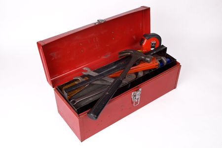 Old used and rusty tools in a red toolbox over a white background