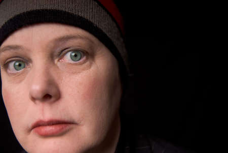 Woman wearing a knit hat over a black background