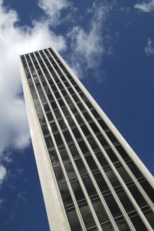 front detail of an urban office building with a blue sky and clouds