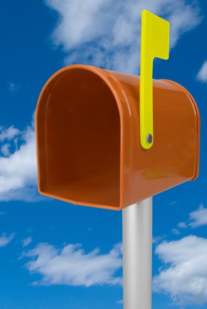 A standard orange mailbox and flag isolated over a blue skyの写真素材