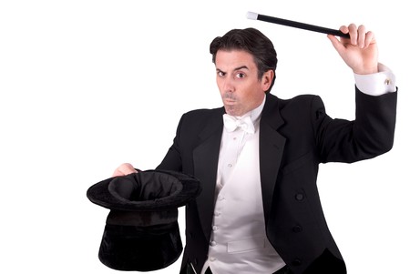 Magician holding a magic wand and a hat isolated over white backgroundの写真素材