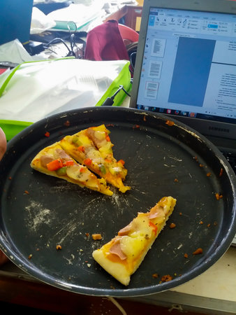 The remaining pizza is in the pan on the workの写真素材