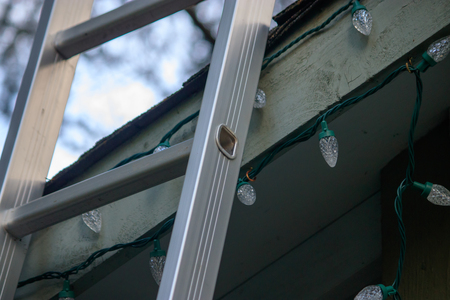ladder leaning up on roof to decorate for christmas