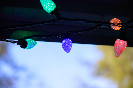 colorful glowing lights under the roof line of a house