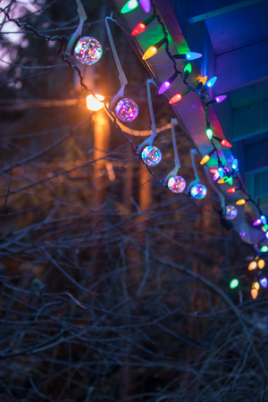 strings ofcolorful christmas lights hanging from a roofの写真素材