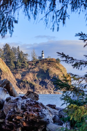 bright lighthouse in pacific norhtwest overlooking pacific oceanの写真素材