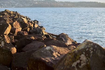 late afternoon sun on rocks and waterの写真素材