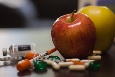 apples surrounded by pillsの写真素材