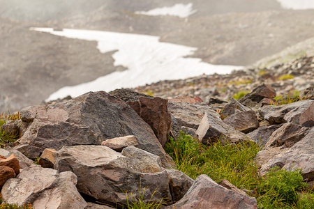 crumbling volcanic soil with rocks near snow fields in washington state