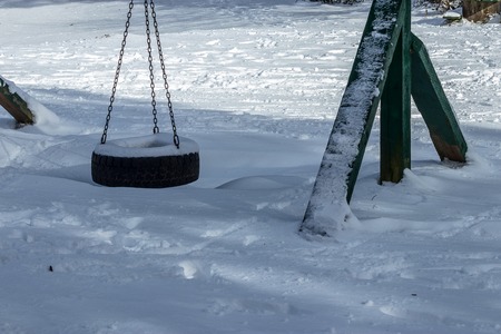 tire swing in a park mounted on a green wooden frameの写真素材